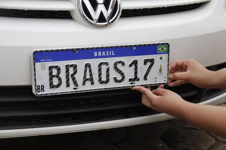 Placa mercosul sendo colocada em carro da Volkswagen
