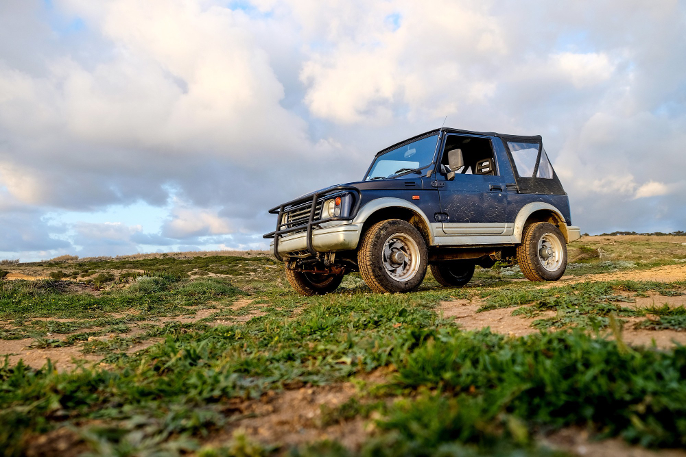 Carro estilo "jipe" em um cenário de natureza