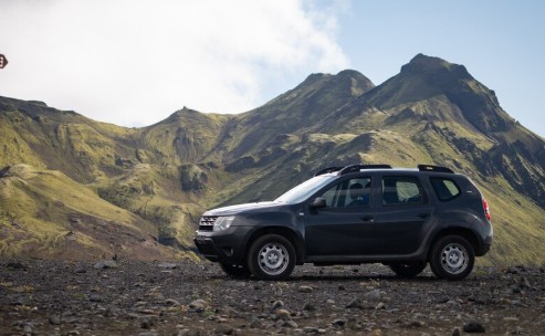 Carro estilo "SUV" em cor escura, em um cenário de natureza